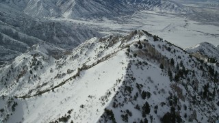 AX125_150 - 5.5K aerial stock footage approach snow-covered Oquirrh Mountains peak in winter, Utah