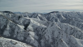 AX125_161 - 5.5K aerial stock footage of rugged Oquirrh Mountains with snow in wintertime, Utah