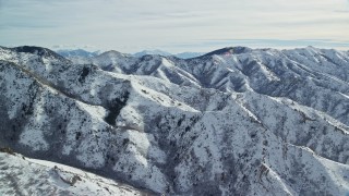 AX125_161E - 5.5K aerial stock footage of rugged Oquirrh Mountains with snow in wintertime, Utah