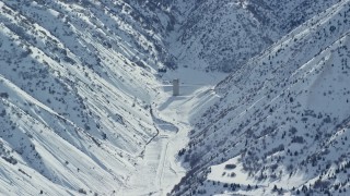 AX125_165 - 5.5K aerial stock footage of lone building in the Oquirrh Mountains with winter snow, Utah