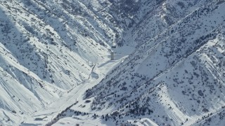 AX125_168 - 5.5K aerial stock footage of a solitary building in Oquirrh Mountains' Baltimore Gulch with wintertime snow, Utah