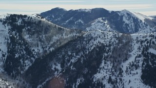 AX125_171E - 5.5K aerial stock footage of a Oquirrh Mountains ridge with snowdrifts in winter, Utah