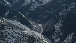AX125_176 - 5.5K aerial stock footage of clearing at the end of a snowy mountain road in the Oquirrh Mountains, Utah