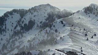 AX125_185E - 5.5K aerial stock footage of Oquirrh Mountains with snowdrifts in wintertime, Utah