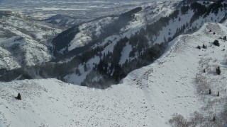 AX125_193E - 5.5K aerial stock footage of snowdrifts on peak and ridge in the Oquirrh Mountains, Utah
