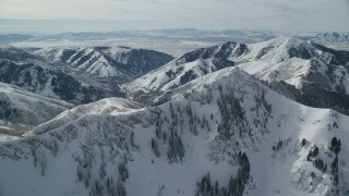 AX125_207 - 5.5K aerial stock footage orbiting Rocky Peak with winter snow, Oquirrh Mountains, Utah