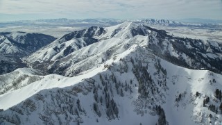 AX125_207E - 5.5K aerial stock footage orbiting Rocky Peak with winter snow, Oquirrh Mountains, Utah