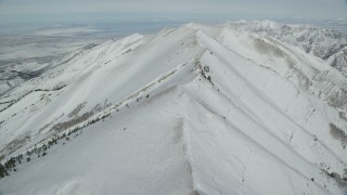 AX125_215 - 5.5K aerial stock footage of flying over a wintery ridge in the Oquirrh Mountains of Utah