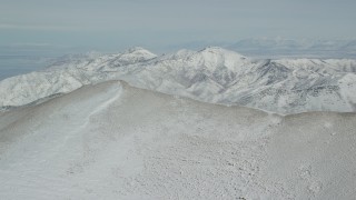 AX125_218 - 5.5K aerial stock footage approach snowdrift from Oquirrh Mountains ridge in wintertime, Utah