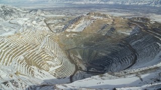 AX125_229E - 5.5K aerial stock footage of the Bingham Canyon Mine in winter with light snow in Utah