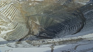 AX125_231 - 5.5K stock footage aerial video of the bottom of the Bingham Canyon Copper Mine with winter snow, Utah