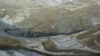 AX125_235 - 5.5K aerial stock footage orbit the edge of the Bingham Canyon Mine covered in light snow, Utah