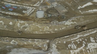 AX125_237 - 5.5K aerial stock footage of orbiting gravel haulers in the Bingham Canyon Copper Mine in winter, Utah