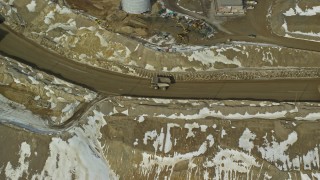 AX125_237E - 5.5K aerial stock footage of gravel haulers in the Bingham Canyon Copper Mine in winter, Utah