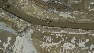 AX125_238 - 5.5K aerial stock footage orbiting a group of gravel haulers at Bingham Canyon Mine in winter, Utah