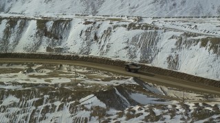 AX125_241 - 5.5K aerial stock footage of tracking a gravel hauler at the Bingham Canyon Mine in snowy Utah