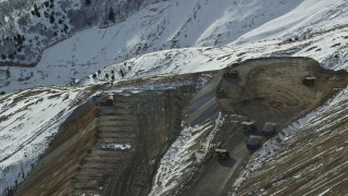 AX125_249 - 5.5K aerial stock footage of gravel haulers working at the Bingham Canyon Mine in winter, Utah