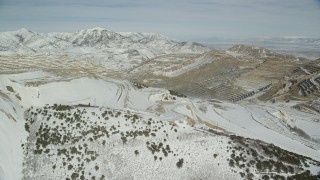 AX125_255 - 5.5K aerial stock footage orbit snowy perimeter of the Bingham Canyon Mine in winter, Utah