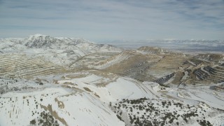 AX125_256 - 5.5K aerial stock footage of a view across the Bingham Canyon Copper Mine with winter snow, Utah