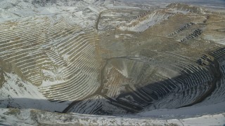 AX125_263 - 5.5K aerial stock footage fly over deep open pit copper mine with winter snow, Bingham Canyon Mine, Utah