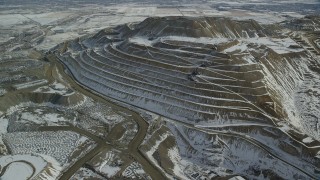 AX125_267 - 5.5K aerial stock footage of orbiting the side of the Bingham Canyon Copper Mine in winter, Utah