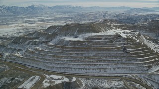 AX125_269 - 5.5K aerial stock footage of snow-dusted tiers of the Bingham Canyon Mine in winter, Utah