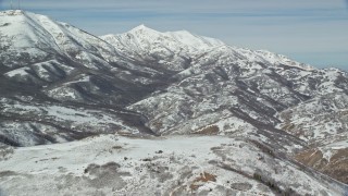 AX125_282 - 5.5K aerial stock footage of snowy Farnsworth and Kessler Peaks in winter, Utah