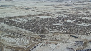 AX125_289E - 5.5K aerial stock footage of homes in the small town of Magna, Utah, with winter snow