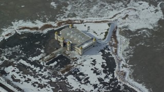 AX125_299E - 5.5K aerial stock footage of orbiting the isolated Saltair Pavilion with winter snow in Magna, Utah
