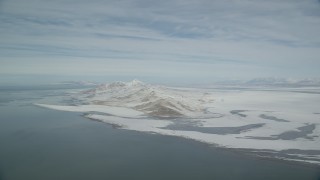 AX125_308 - 5.5K aerial stock footage pan across Great Salt Lake to reveal snowy Antelope Island in winter, Utah