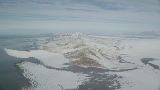 AX125_312 - 5.5K aerial stock footage slow approach to snow mountains on Antelope Island, Utah