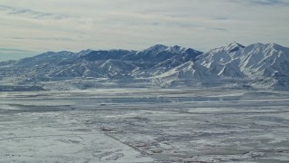 AX125_316E - 5.5K aerial stock footage of white snow on the Oquirrh Mountains of Utah in wintertime