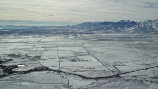 AX125_319 - 5.5K aerial stock footage of the town of Magna and snowy Oquirrh Mountains in winter, Utah