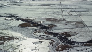 AX125_320E - 5.5K aerial stock footage of small canal through frozen countryside near Salt Lake City in winter, Utah