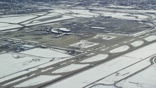 AX125_325E - 5.5K aerial stock footage of tracking commercial jet on runway at SLC Airport with winter snow