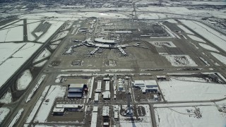AX125_330E - 5.5K aerial stock footage of control tower and terminals at Salt Lake City International Airport with winter snow, Utah