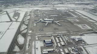 AX125_331 - 5.5K stock footage aerial video orbit terminals, runways and control tower at SLC Airport with winter snow, Utah