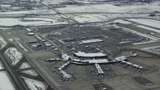 AX125_332 - 5.5K aerial stock footage orbit terminals and parking lot at Salt Lake City Airport with winter snow, Utah