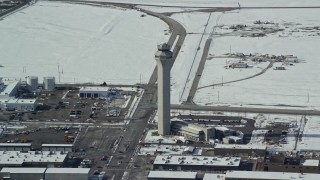 AX125_334 - 5.5K aerial stock footage reverse from control tower at Salt Lake City International Airport with winter snow, Utah