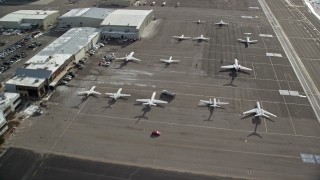 AX126_002 - 5.5K stock footage aerial video fly over hangars and private planes at Salt Lake City Airport in winter, Utah