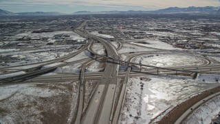 AX126_003E - 5.5K aerial stock footage of a freeway and nearby interchange in Salt Lake City in winter, Utah