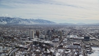 AX126_013E - 5.5K aerial stock footage orbit of Downtown Salt Lake City buildings with light winter snow, Utah