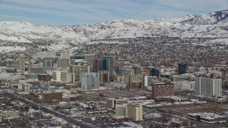 AX126_024E - 5.5K aerial stock footage orbit south side of Downtown Salt Lake City with winter snow, Utah