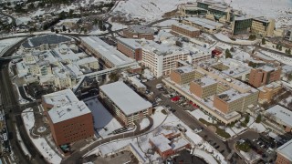 AX126_052 - 5.5K aerial stock footage orbit University of Utah hospital with winter snow, Salt Lake City