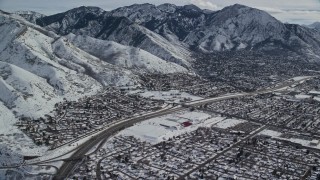 AX126_066 - 5.5K aerial stock footage of suburban neighborhoods around Interstate 215 in snowy Salt Lake City, Utah