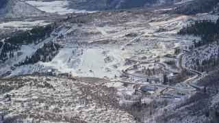 AX126_094 - 5.5K aerial stock footage approach Utah Olympic Park with winter snow, Park City, Utah