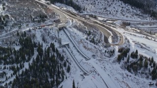 AX126_099E - 5.5K aerial stock footage orbiting the ski jumps at Utah Olympic Park with winter snow in Park City