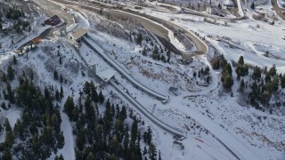 AX126_108E - 5.5K aerial stock footage of a pair of ski jumps with winter snow at Utah Olympic Park in Park City, Utah