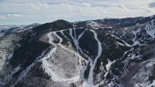 AX126_115 - 5.5K aerial stock footage of approaching Canyons Resort ski runs on a snowy Iron Mountain slope, Park City