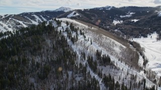 AX126_120 - 5.5K aerial stock footage orbit gondolas running up a snowy mountain slope in Park City, Utah